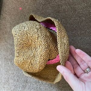 Woman’s straw fedora with pink ribbon